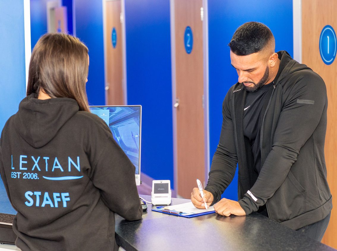 A dark haired women serving a man in a lextan shop