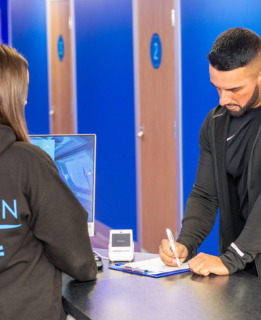 A dark haired women serving a man in a lextan shop