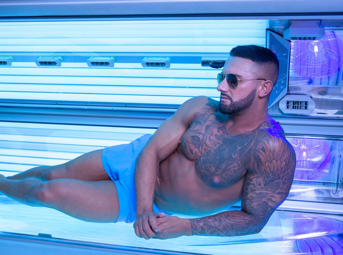 A muscular man on a sunbed