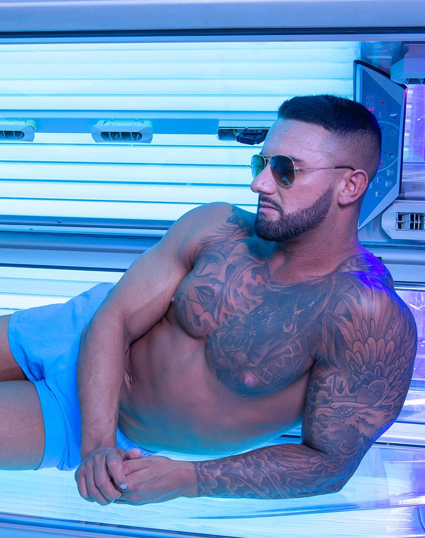 A muscular man on a sunbed